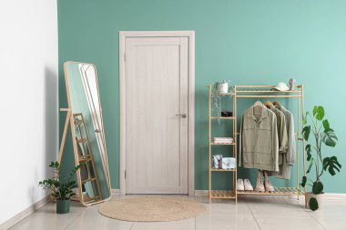 Elbise askılığı, aynası ve kapısı olan şık bir koridor.