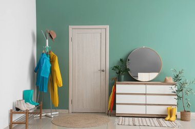 Kapısı, yağmurluğu ve tuvaleti olan şık bir koridor.