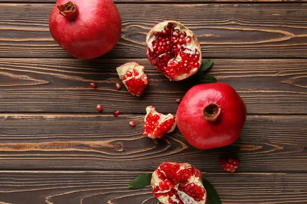 Tahta zemin üzerinde tohum ve yapraklarla taze olgun narlar.