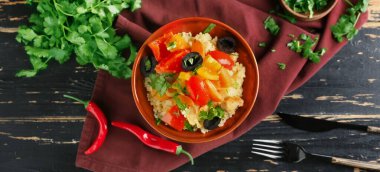 Koyu ahşap arka planda kuskus ve sebzeli kase.