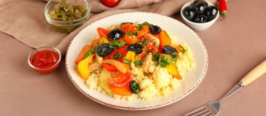 Arka planda kuskus ve sebzeli tabak