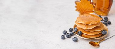 Beyaz arka planda yaban mersinli ve akçaağaç şuruplu lezzetli krepler.