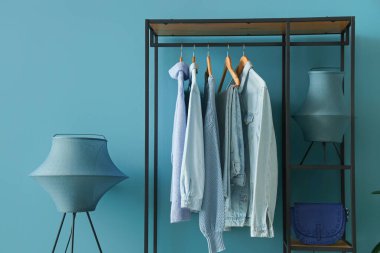 Raflar, elbiseler ve lambalarla dolu soyunma odasının içinde.