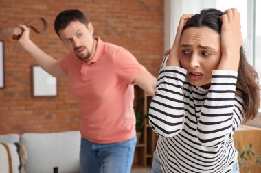 Evde kızgın kocasıyla korkmuş genç bir kadın. Aile içi şiddet kavramı