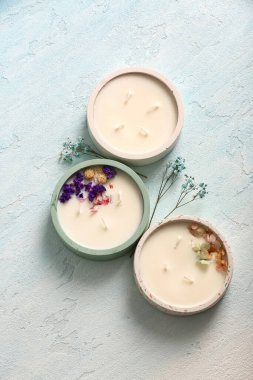 Mavi arka planda mumları ve çiçekleri olan tutucular