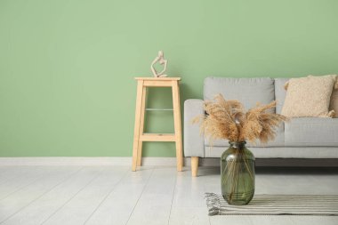 Oturma odasının içinde, kanepede ve vazoda kamış var.