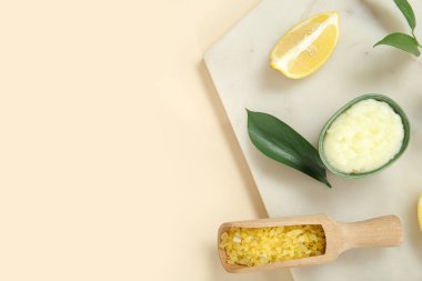 Kase limonlu vücut fırçası ve bej arka planda deniz tuzu.