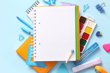 Mavi arkaplanda boş defter ve farklı okul sayfası olan kompozisyon, yakın plan