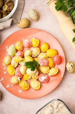 Beyaz arka planda renkli çiğ hamur köfteleri ve maydanozlu tabak.