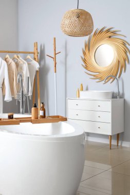 Banyonun içinde altın ayna, lavabo ve küvet var.