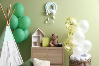 İçinde balonlar, çadır ve oyuncaklar olan çocuk odasının içi.