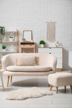 Beyaz rahat kanepesi ve ayak sehpası olan modern oturma odası.