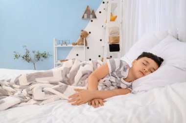 Yatak odasında uyuyan sevimli küçük çocuk.