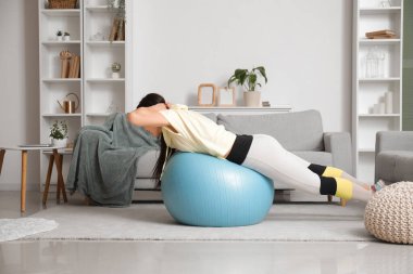 Sportif genç Asyalı kadın evde spor yapıyor.