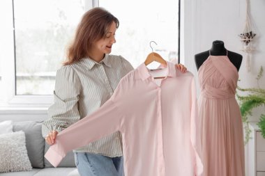 Giyim kuşamında bluz seçen güzel genç bir kadın.