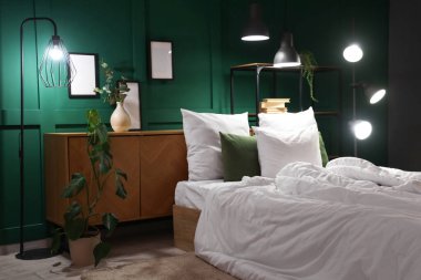 Şık bir yatak odası, rahat bir yatak odası, çiçekler ve geceleri parlayan lambalar.