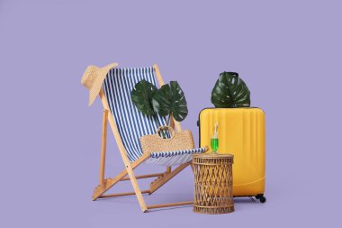 Çizgili iskemle, tropikal yapraklar, şapka, çanta ve masa.