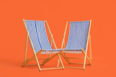 Turuncu arka planda çizgili güverte sandalyeleri