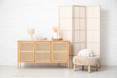 Katlanmış perdeli, puf ve sandıklı modern odanın içi.