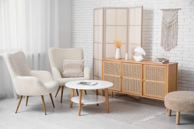 Katlanan ekran, koltuk ve masa ile modern odanın içi