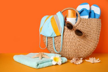 Güneş kremi şişesi, mayo ve plaj aksesuarlarıyla dolu bir çöp torbası.