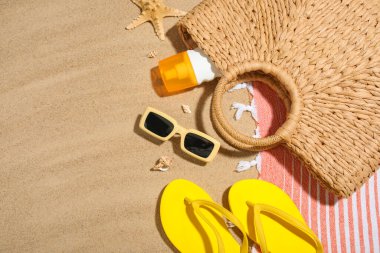 Arka planda güneş kremi, deniz kabuğu ve kumsal aksesuarları olan kompozisyon, yakın plan.