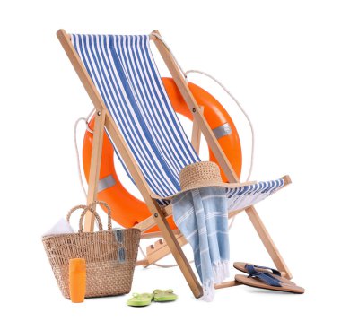 Çizgili iskemle, güneş kremi şişeleri ve beyaz arka planda izole edilmiş plaj aksesuarları.