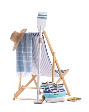 Kürek, çizgili iskemle ve beyaz arka planda izole edilmiş plaj aksesuarları.