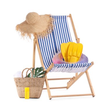 Çizgili iskemle, güneş kremi şişesi ve beyaz arka planda izole edilmiş plaj aksesuarları.