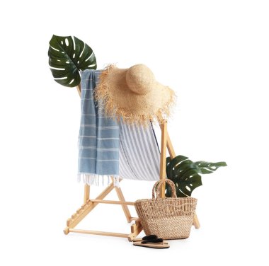 Çizgili iskemle, tropikal yapraklar ve beyaz arka planda izole edilmiş plaj aksesuarları.