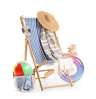 Çizgili iskemle, oyuncak top ve beyaz arka planda izole edilmiş plaj aksesuarları.