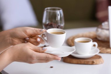 Evde bir fincan sıcak kahveyle kadın elleri