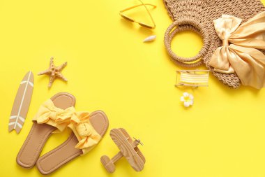 Sarı arka planda plaj aksesuarları olan yaz kompozisyonu