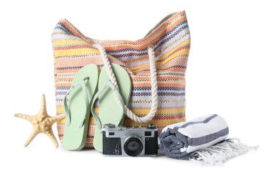 Plaj çantası, fotoğraf makinesi ve plaj aksesuarları beyaz arka planda izole edilmiş, yakın plan.