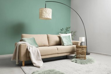 Gri kanepesi, masası ve lambası olan şık bir oturma odası.