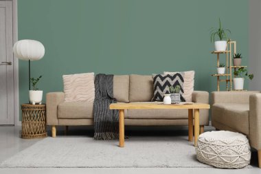 Oturma odasının içinde rahat koltuklar, puf ve masa, yakın çekim.