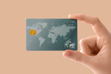 Bej arka planda kredi kartı olan bir kadın, yakın plan.