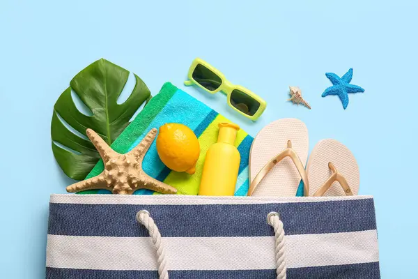 Limonlu, yeşil yapraklı ve mavi arka planda plaj aksesuarlı yaz kompozisyonu