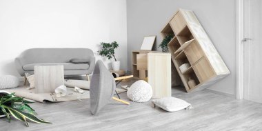 Depremden sonra mobilyaların devrildiği dağınık bir oturma odası.