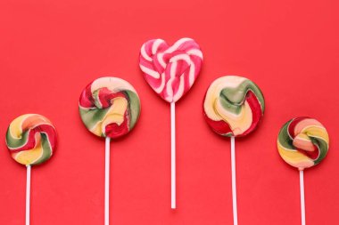Kırmızı arka planda tatlı lolipoplar