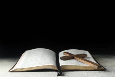 Kutsal İncil, üzerinde ahşap haç ve koyu arkaplan