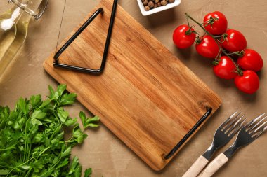 Ahşap mutfak tahtası, çatallar, domatesler ve renkli arka planda maydanoz