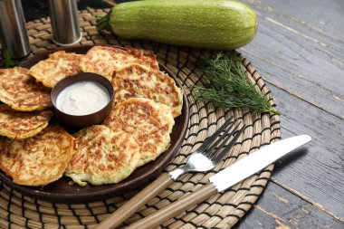 Siyah ahşap arka planda ekşi kremalı bir tabak lezzetli kabak böreği.