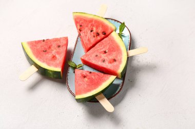 Tatlı karpuz çubukları ve beyaz arka planda nane şekeri.