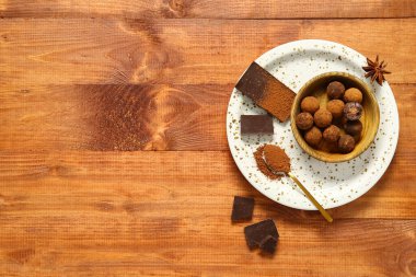 Tahta arka planda lezzetli çikolatalı trüf mantarlı kase.