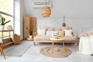 Beyaz kanepesi, koltuğu ve kahve masası olan bir oturma odası.