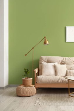 Modern oturma odasının içinde rahat bir kanepe ve standart lamba var.