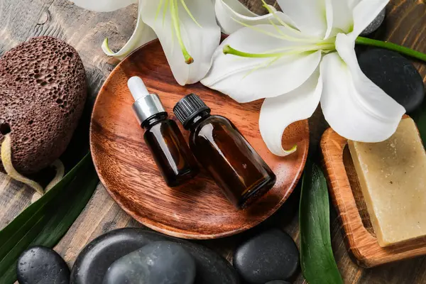 Kozmetik ürünleri şişeleri, spa aksesuarları ve ahşap arka planda zambak çiçekleri olan kompozisyon