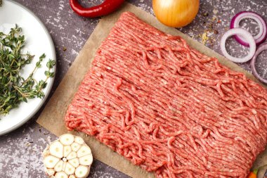 Gri arka planda baharatlı taze kıyma.