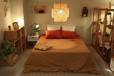 Rahat yatak odasının içinde raf üniteleri ve geceleri parlayan lambalar.